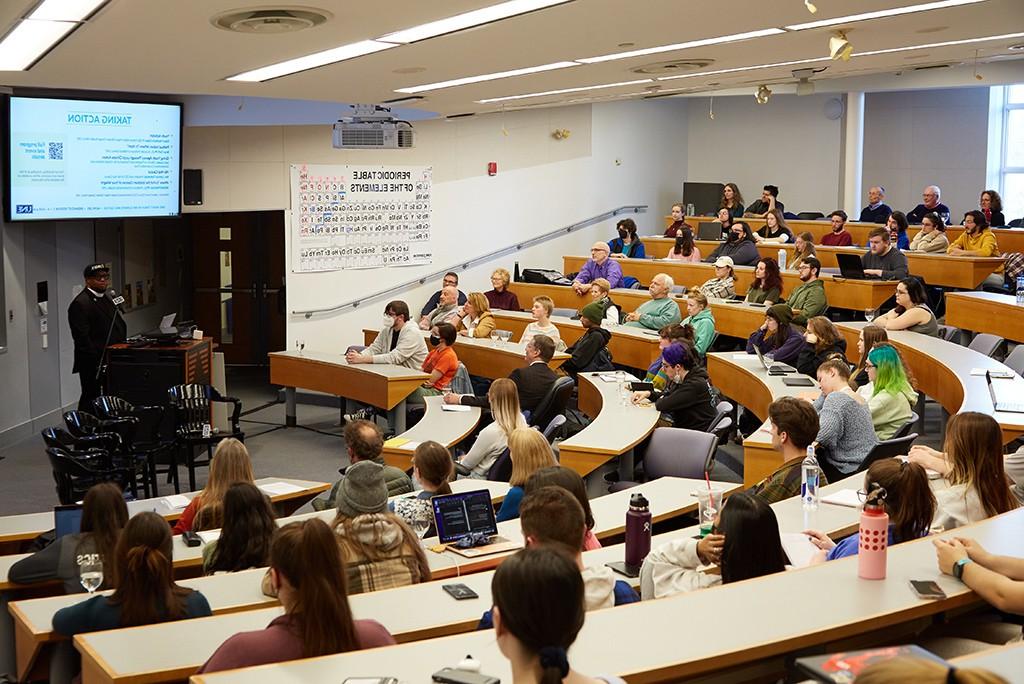 学生 in a lecture hall listening to a speaker at a Climate Teach-In event