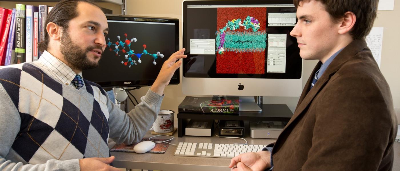 U N E professor and 学生 by a molecular model on a computer