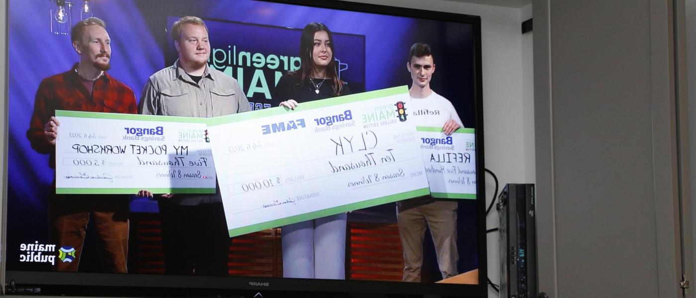 Anderson is shown on the television holding the winning, $10,000 check. 她的竞争对手拿着第二名和第三名的支票.