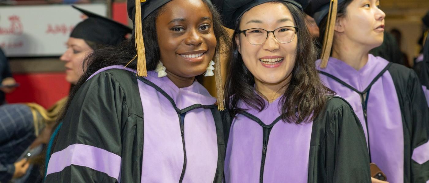 Two graduates pose for a photo