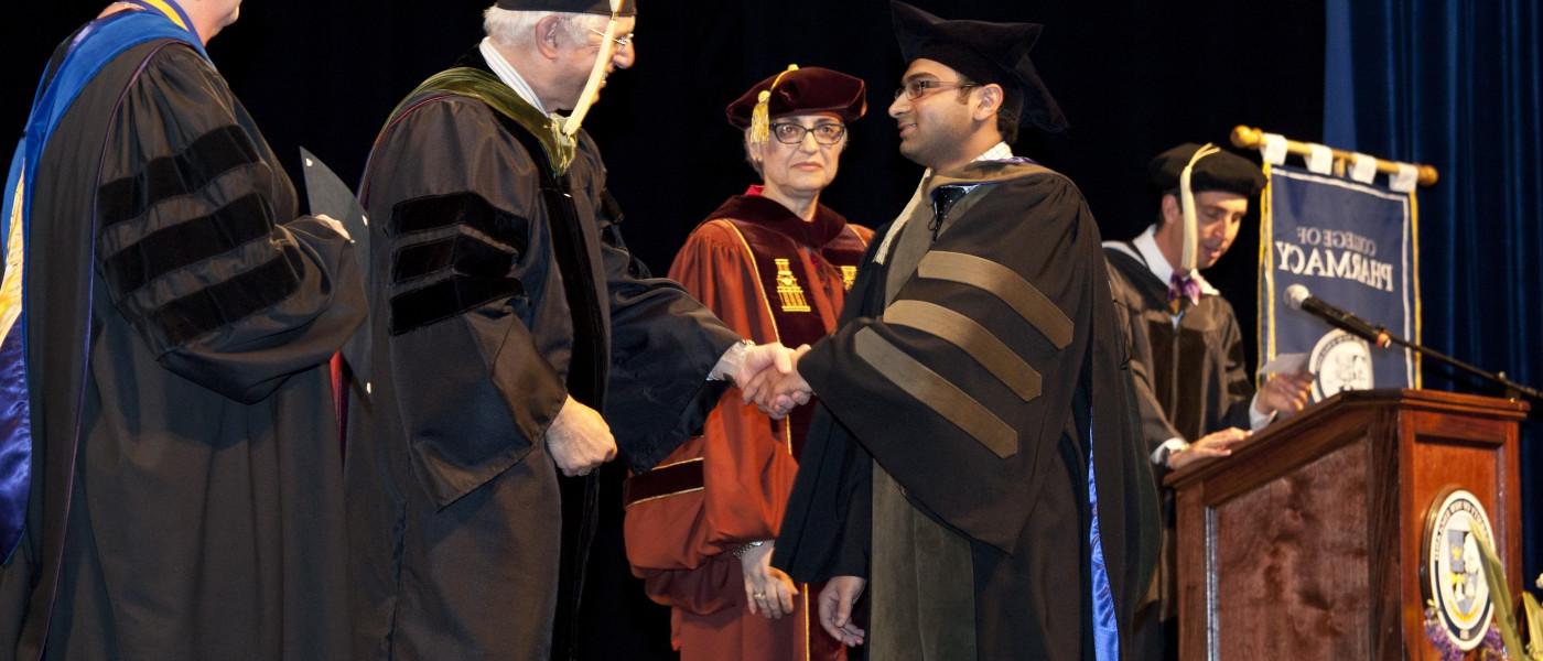 一位药学专业的学生在毕业典礼上接受他的毕业证书 