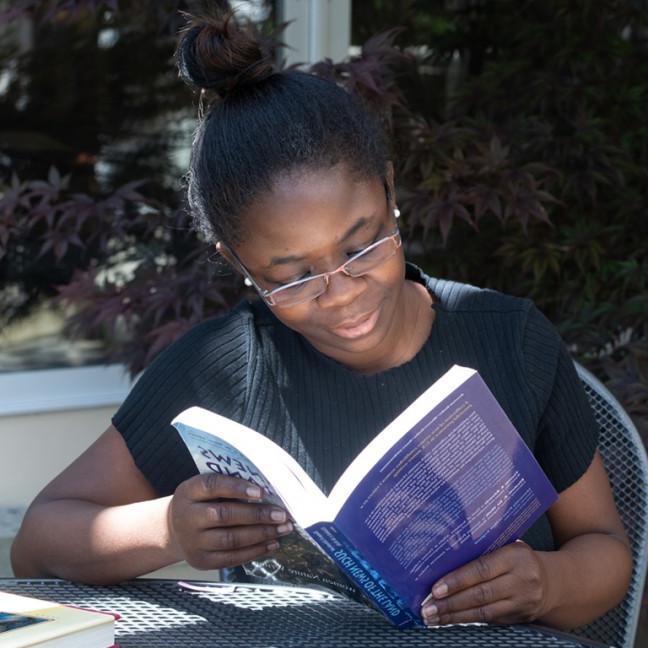 一个学生坐在外面看书