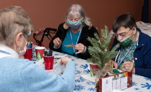 人 paint holiday-themed crafts at a wellness fair for Westbrook Housing residents