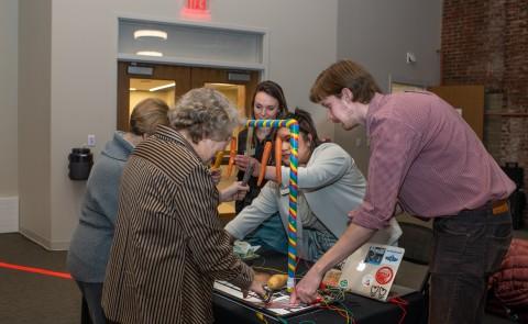 Expo attendees play with a sensory piano created by M.S.O.T. 学生