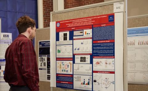 一名学生在第一届生物医学研究与工程年度研讨会上阅读研究海报