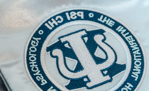 A photo of a stole bearing the PSI CHI logo