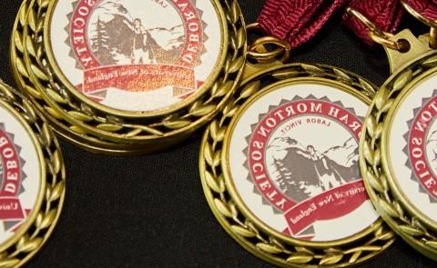 几枚印有黛博拉·莫顿协会印章的奖牌摊开在桌子上