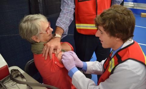 一名正规澳门赌场网络医学院的学生在疫苗接种诊所做志愿者